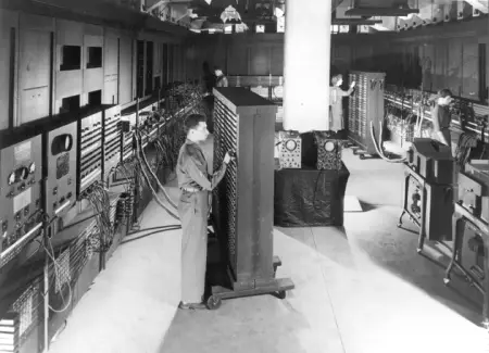 Cpl. Irwin Goldstein (foreground) sets the switches on one of the ENIAC's function tables at the Moore School of Electri